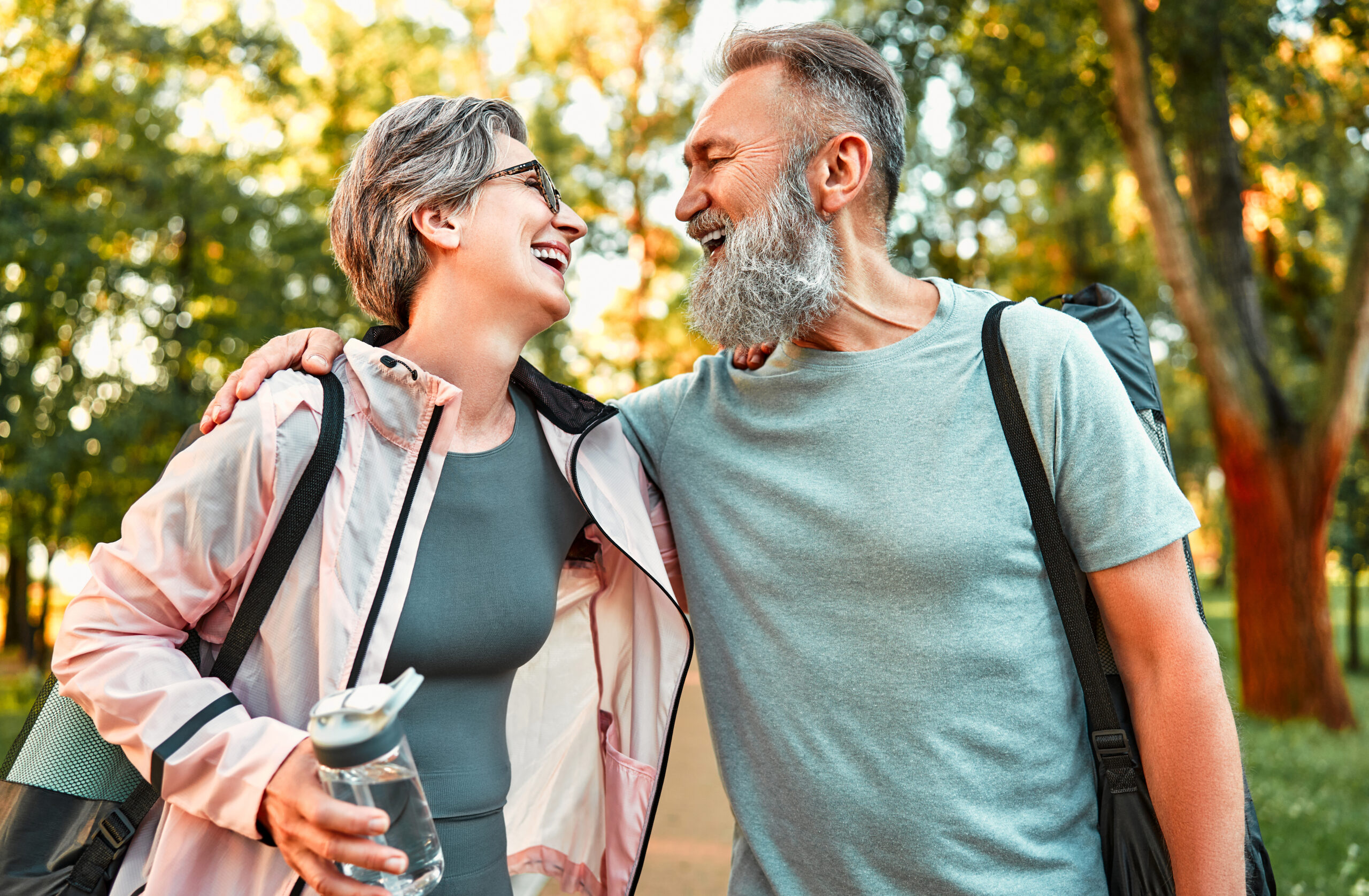 A happy senior couple enjoys walking in the park after receiving bone density support through Marodyne.