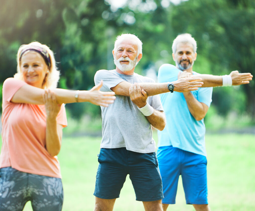 Active seniors stretching outdoors together, supporting bone health through regular weight-bearing exercise
